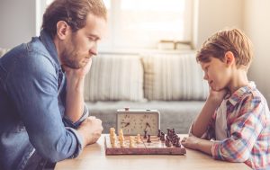 uomo e bambino giocano a scacchi